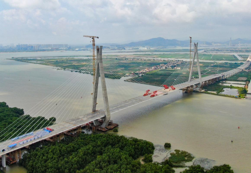 南中高速連通廣州、中山、深圳三市，是國家高速公路網(wǎng)G2518和廣東省高速公路網(wǎng)S78的重要組成部分，也是粵港澳大灣區(qū)重大交通基礎(chǔ)設(shè)施項目。其中的洪奇門特大橋全長1126米，為主跨520米的雙塔雙索面鋼箱梁斜拉橋，是南中高速項目的關(guān)鍵控制性工程。2023年5月21日上午，南中高速洪奇門特大橋順利合龍，實現(xiàn)了廣州、中山兩市實現(xiàn)跨江“牽手”。圖為南中高速洪奇門特大橋。