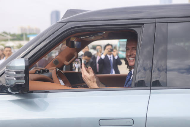 △在深圳，紐森現(xiàn)場試乘比亞迪電動汽車。