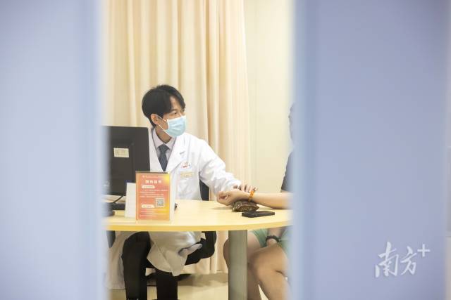 梁偉衡在給病人看診。