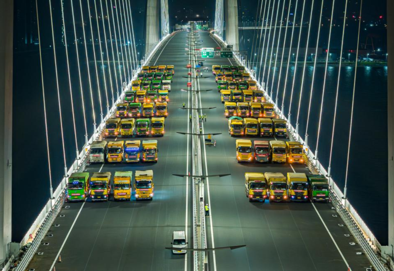 2024年4月17日，深中通道橋梁工程完成荷載試驗(yàn)。最大達(dá)136輛、總重約5000噸的大貨車組對深中通道中山大橋、深中大橋非通航孔引橋進(jìn)行荷載試驗(yàn)，通過等效模擬通車后的荷載情況，現(xiàn)場測試橋梁各部位的反應(yīng)數(shù)據(jù)，判斷橋梁承載能力是否符合設(shè)計(jì)要求和相關(guān)規(guī)范要求，為交工驗(yàn)收提供原始數(shù)據(jù)。圖為大貨車組為深中通道進(jìn)行橋梁荷載試驗(yàn)。