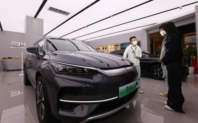 比亞迪店內(nèi)，一名銷售人員（左）正在向兩位顧客介紹車輛信息。深圳特區(qū)報(bào)記者 楊浩翰 攝