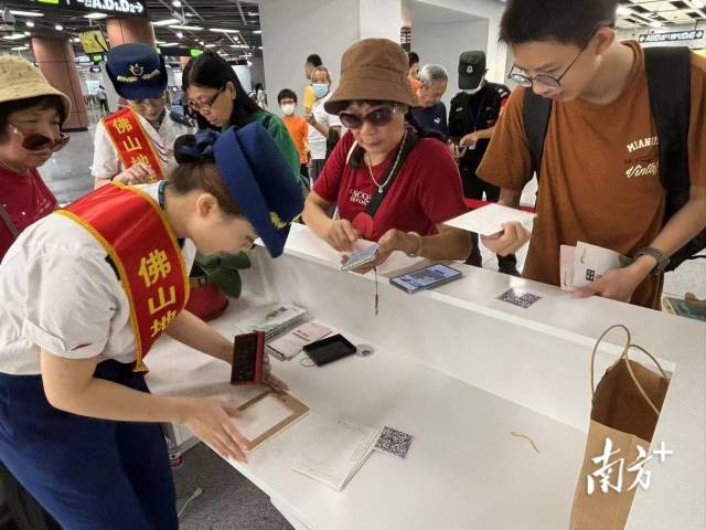 市民在桂城站便民服務(wù)臺用明信片蓋章打卡。龍西男 攝