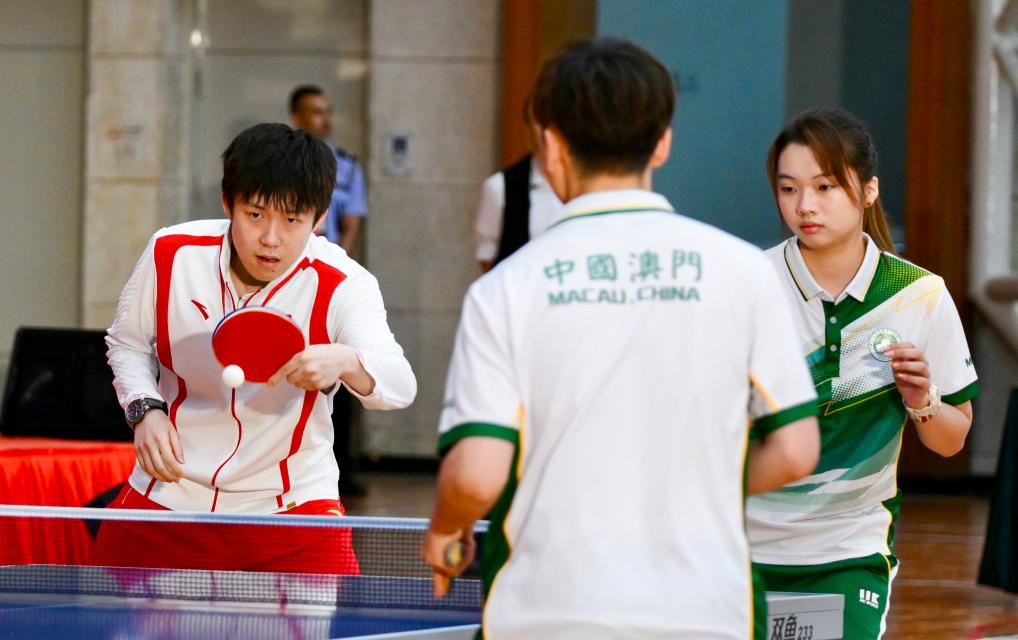 9月1日，乒乓球運動員王楚欽（左）與澳門運動員切磋球技。當日，內(nèi)地奧運健兒代表團在澳門奧林匹克體育中心室內(nèi)體育館與澳門青少年運動員進行互動交流。新華社記者 郭雨祺 攝