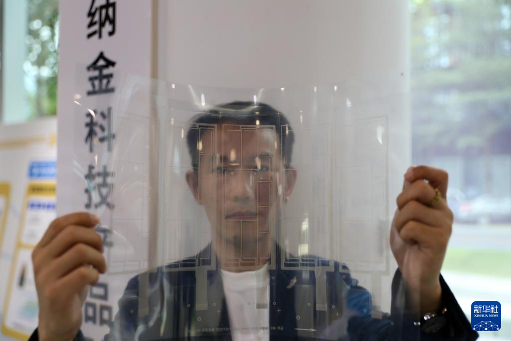 11月25日，在橫琴澳門青年創(chuàng)業(yè)谷，納金科技有限公司工作人員展示一張柔性透明導(dǎo)電材料