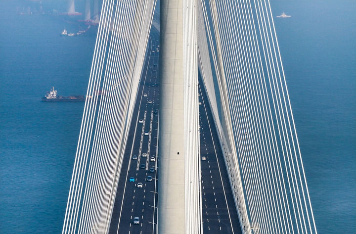 黃茅?？绾Ｍǖ勒酵ㄜ嚭?，車輛行駛在黃茅海大橋上（2024年12月11日攝，無人機(jī)照片）。新華社記者 劉大偉 攝