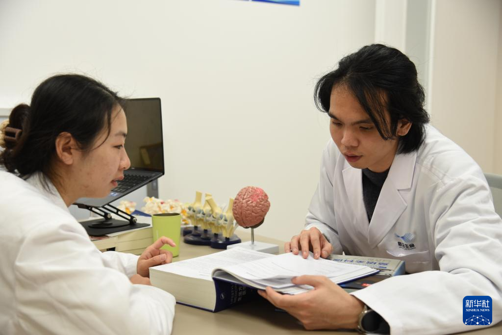 澳門醫(yī)生繆永銳（右）和同事進行交流（12月17日攝）。新華社記者 洪澤華 攝