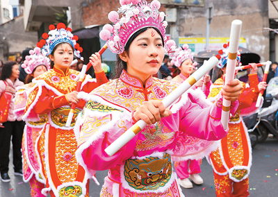  春節(jié)期間，英歌舞隊(duì)員在廣東省汕頭市潮陽(yáng)區(qū)海門鎮(zhèn)街頭巡游表演。王文攝（人民視覺(jué)）