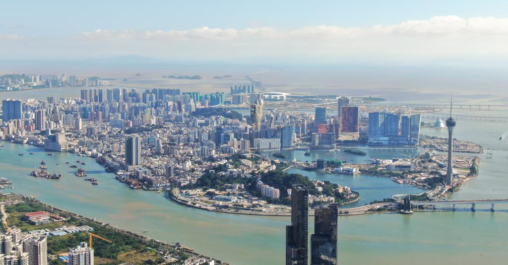 從珠海市區(qū)拍攝的澳門及遠(yuǎn)處的港珠澳大橋（2024年11月26日攝，無人機(jī)照片）。新華社記者 鄧華 攝