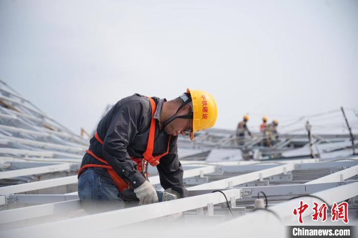 建設(shè)者們忙于幕墻工程、金屬屋面、機(jī)電安裝、精裝修施工。記者 韋杰夫 攝