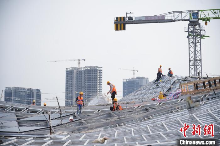 建設(shè)者們忙于幕墻工程、金屬屋面、機(jī)電安裝、精裝修施工。記者 韋杰夫 攝