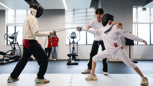 圖為廣東現(xiàn)代五項運動協(xié)會教練員肖勇炫（右二）糾正廣州市中黃港澳子弟學(xué)校港籍生尹澤語的擊劍技術(shù)動作